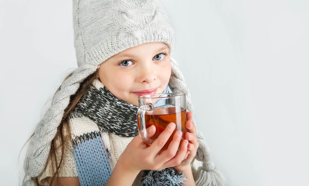 young girl in beanie with hot tea