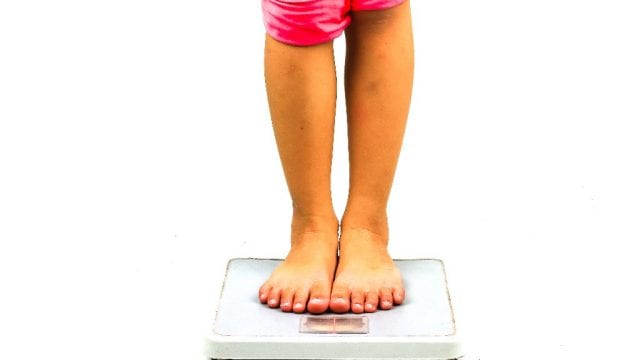 child standing on a scale