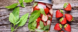 strawberry and mint flavored water on wood background