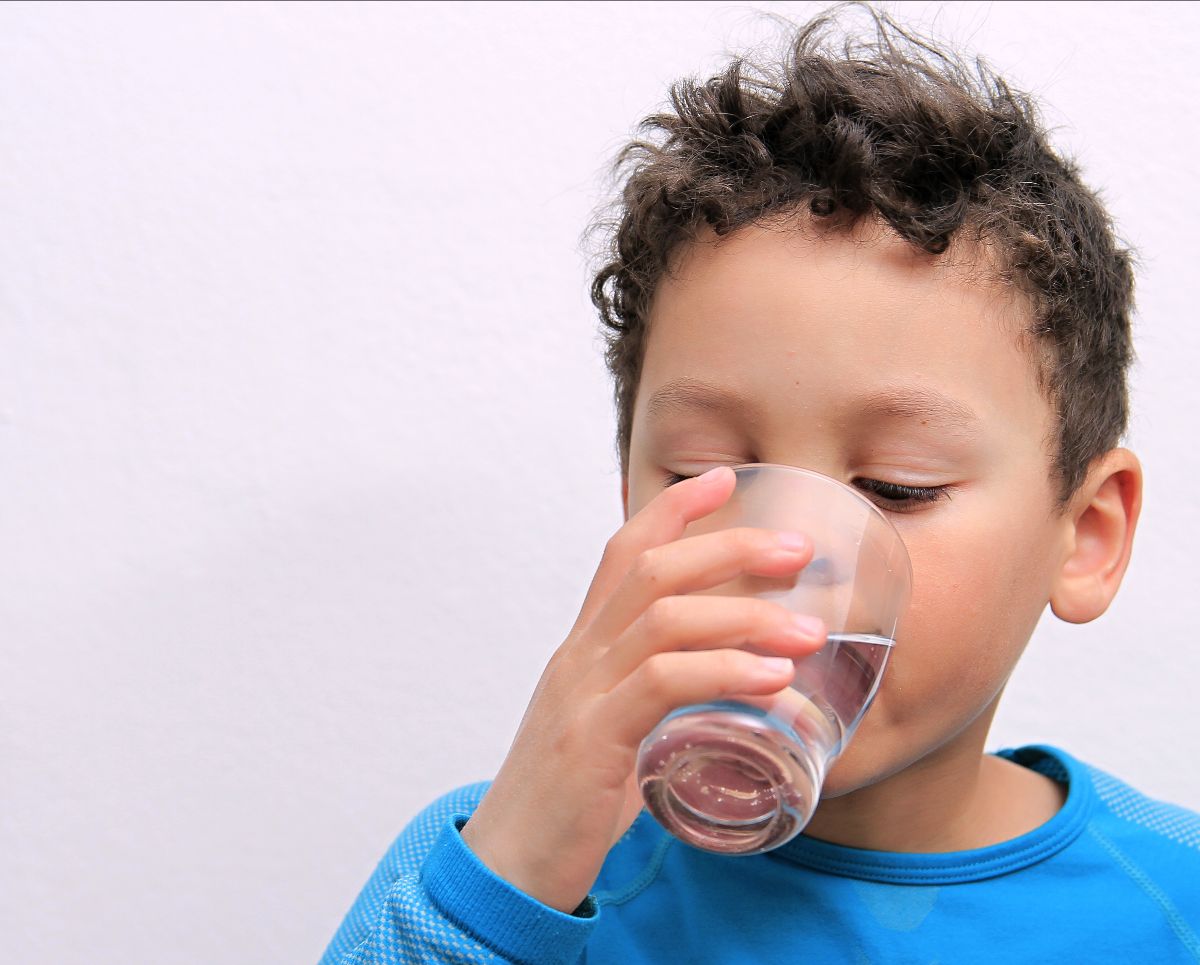Boy wearing blue shirt drinking water