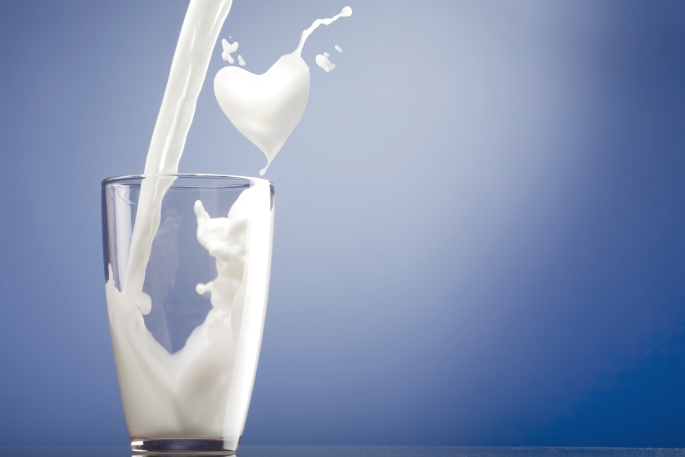 Glass of milk with heart shaped splash